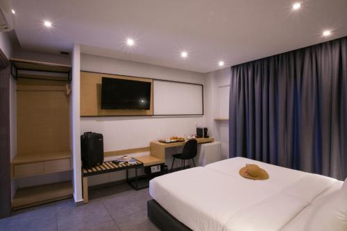 a hotel room with a bed and a desk and a tv at White Luxury in Thessaloniki