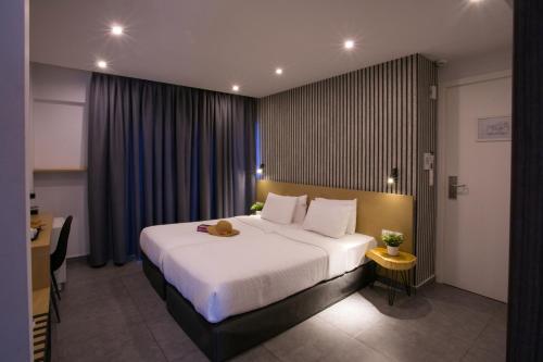 a hotel room with a large bed and a desk at White Luxury in Thessaloniki