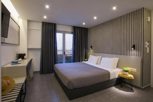 a hotel room with a bed and a desk at White Luxury in Thessaloniki