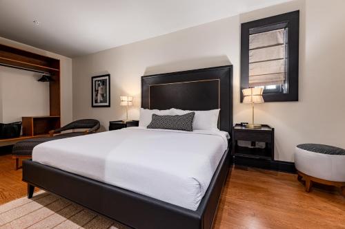a bedroom with a large white bed and a chair at The Mayfair in New Orleans