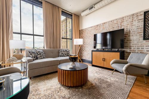 a living room with a couch and a tv at The Mayfair in New Orleans