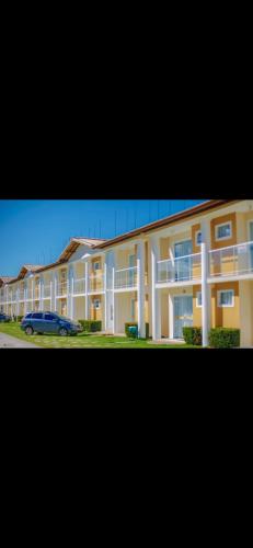 a large building with a car parked in front of it at Apartamento próximo à praia de taperapuã in Porto Seguro