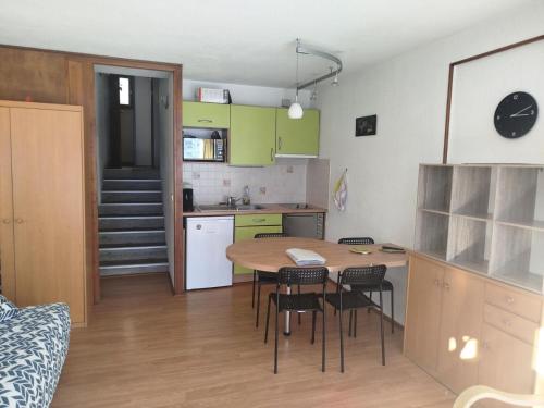 une cuisine avec une table et des chaises dans une pièce dans l'établissement Résidence Plein Ciel - maeva Home - Studio 4 personnes - Confort MAE-9791, à La Mongie