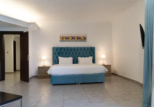 a bedroom with a blue bed and two lamps at Faris Villas للعائلات فقط-الصفحة الرسمية لمنتجع فلل فارس in Al Khīrān