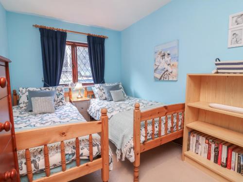 2 Betten in einem Schlafzimmer mit blauen Wänden in der Unterkunft Old Farm Cottage in Ilfracombe