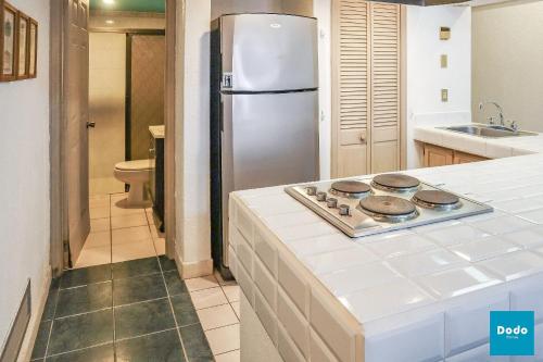 a kitchen with a stove and a refrigerator at Departamento en Mazatlán a 5 minutos de la playa in Mazatlán