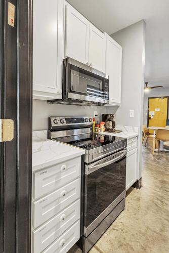 a kitchen with white cabinets and a stove top oven at Large Flexible Family Suite With Private Rooms in Pacific