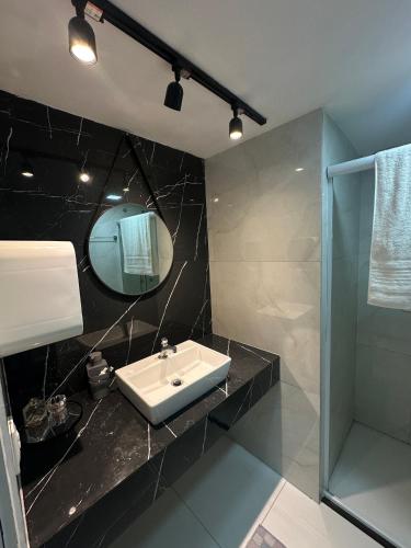 a bathroom with a sink and a shower and a mirror at Eco Paradise Apto 214 in Caucaia