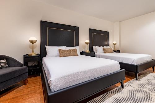 a bedroom with two beds and a couch at The Mayfair in New Orleans