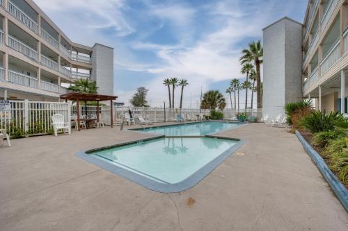 a swimming pool in a courtyard of a building at Steps to Beach Corpus Christi Condo with Balcony in Corpus Christi