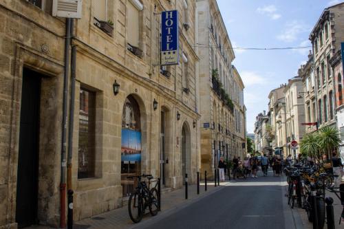 a street in a city with buildings and bikes parked at Hôtel Notre Dame in Bordeaux