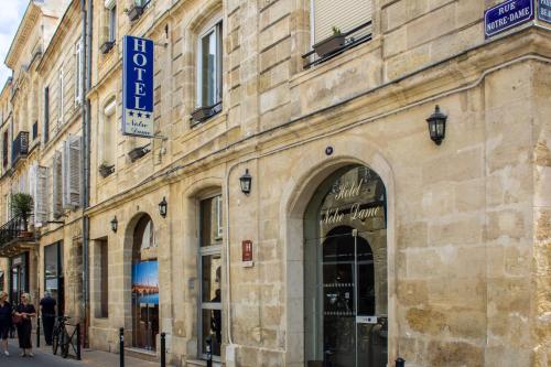 a building with a sign on the side of it at Hôtel Notre Dame in Bordeaux