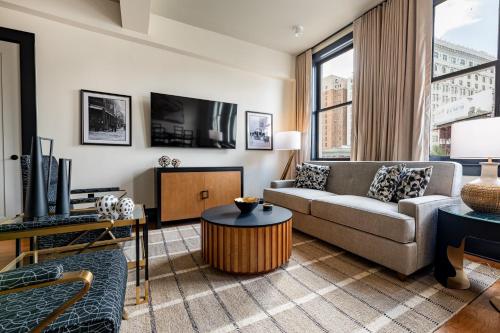 a living room with a couch and a tv at The Mayfair in New Orleans