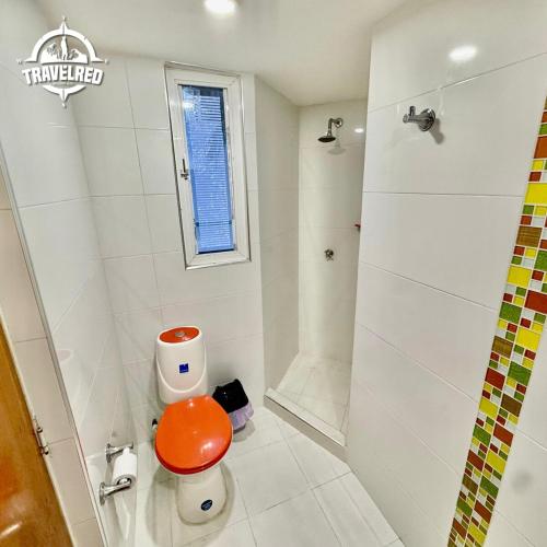 a white bathroom with a toilet and a shower at Tu Refugio Tropical Cerca al Mar in Santa Marta