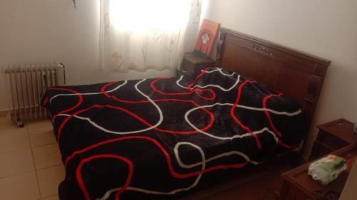 a bed with a black and red blanket on it at Dolce Vita Nid Douillet alias Havre de Paix O Coeur d Ifrane in Ifrane