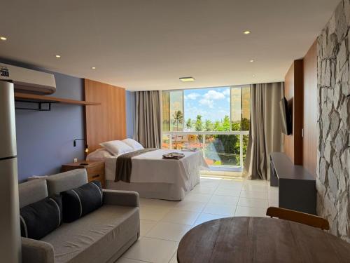 a hotel room with a bed and a couch at Costa Serena Flats - Ponta de Campina in Cabedelo