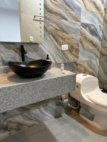 a bathroom with a sink and a toilet at Hotel Boutique Campestre in Florencia