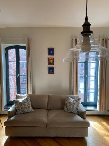 a living room with a couch and a chandelier at Historic 1869 Brownstone 15 min to NYC downtown in Jersey City