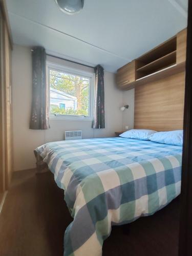 une chambre avec un grand lit avec une fenêtre dans l'établissement Mobil home 6 personnes, à Sainte-Croix-de-Verdon