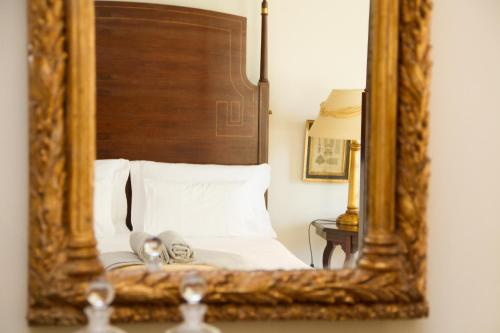 a mirror reflection of a bed in a bedroom at Challet Fonte Nova in Alcobaça