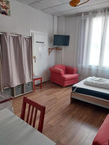 Cette chambre comprend un lit, un canapé et une chaise. dans l'établissement Studio N2 Rez De Chaussée, à Néris-les-Bains