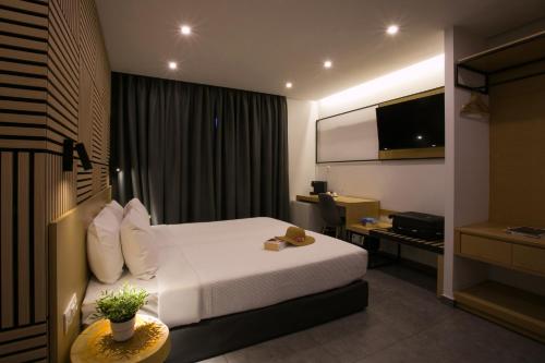 a hotel room with a bed and a flat screen tv at White Luxury in Thessaloniki