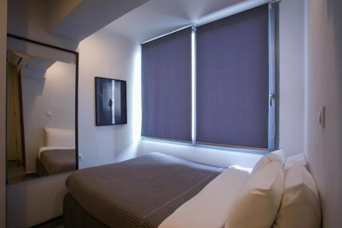 a bedroom with a bed and a large window at White Luxury in Thessaloniki