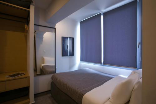a bedroom with a bed and a large window at White Luxury in Thessaloniki