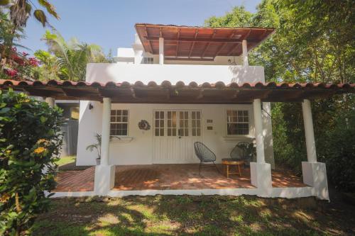 a small white house with a table and a chair at Alma Vida Hotel in Manuel Antonio