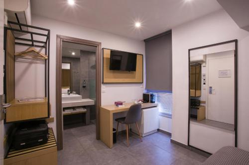 a bathroom with a desk and a sink and a mirror at White Luxury in Thessaloniki