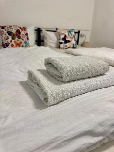 two towels sitting on top of a white bed at Kleine-Romantische Ferienwohnung Parkplatz vor dem Haus! in Altenau