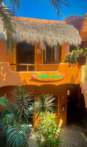 a yellow house with a surfboard on the side of it at Bungalows Jaqueline in Sayulita