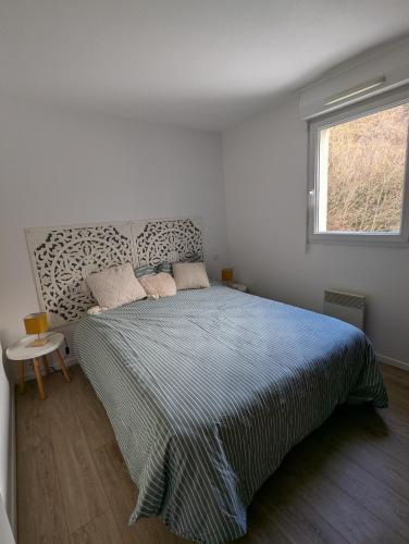 une chambre avec un lit et une fenêtre dans l'établissement T2 chaleureux St Lary village, à Saint-Lary-Soulan