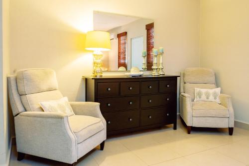 a bathroom with two chairs and a dresser and a mirror at Charming & Family-Friendly Boqueron Village Condos! in Boqueron