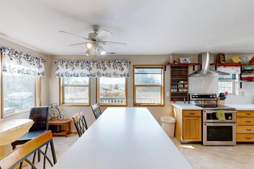 a kitchen with a large white table and some windows at Reedsport Hideaway in Reedsport