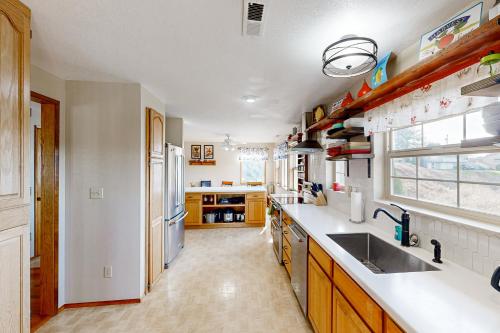 a kitchen with a sink and a refrigerator at Reedsport Hideaway in Reedsport