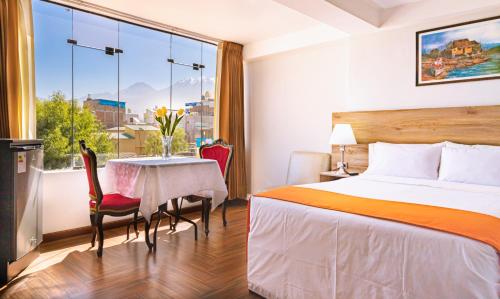 a hotel room with a bed and a table and a window at Hotel Plaza San Antonio Arequipa in Arequipa