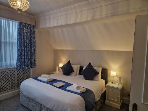 a bedroom with a large bed with two pillows at St Margaret's Hotel in Oxford