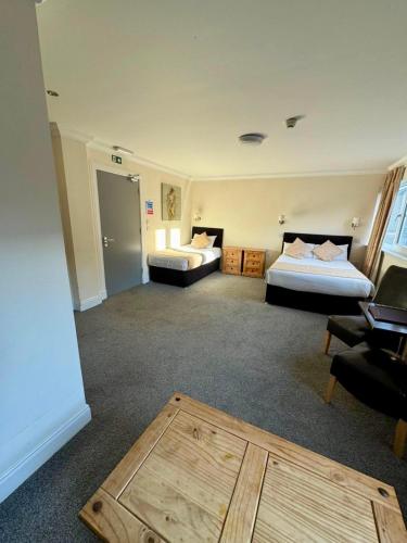 a room with two beds and a table in it at The Waverley Inn in Dingwall