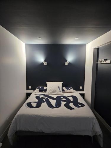 une chambre avec un grand lit avec une tête de lit noire dans l'établissement Le Cocon de Marine, à Triel-sur-Seine