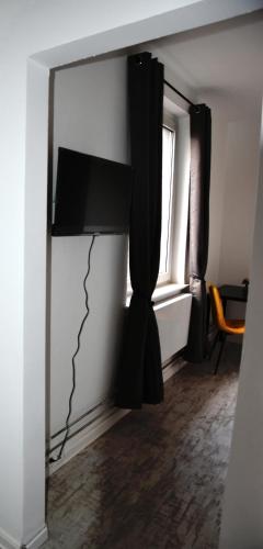 a room with a television on a wall with a window at Villa C&C in Bad Wildungen