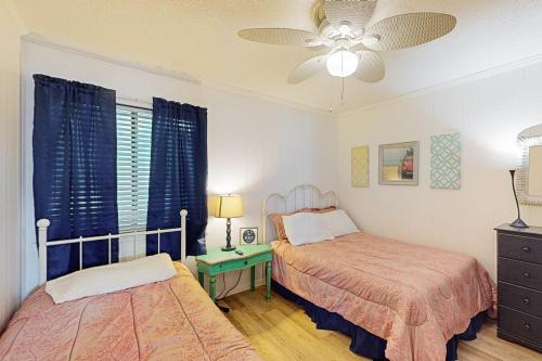 a bedroom with two beds and a ceiling fan at Seaspray 360 in Atlantic Beach