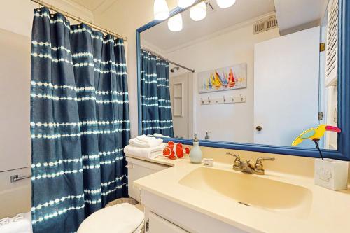 a bathroom with a blue shower curtain and a sink at Seaspray 360 in Atlantic Beach