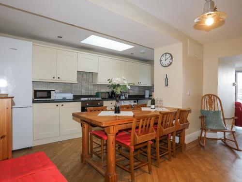 a kitchen with a wooden table and chairs at The Quarterdeck in Porthmadog