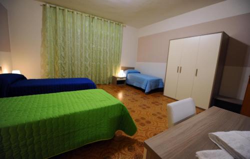 Un dormitorio con una cama verde y un armario en Casa Grande, en Matera