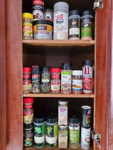 a cabinet filled with lots of different types of food at Firepit Games Grill Hot Tub Arcade & King Bed in Kernersville