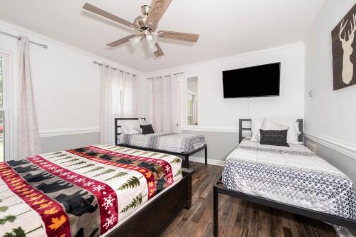 a bedroom with two beds and a flat screen tv at Firepit Games Grill Hot Tub Arcade & King Bed in Kernersville