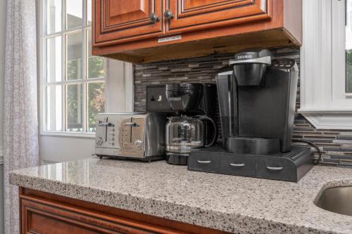 a kitchen counter with a coffeemaker and coffee maker at Firepit Games Grill Hot Tub Arcade & King Bed in Kernersville