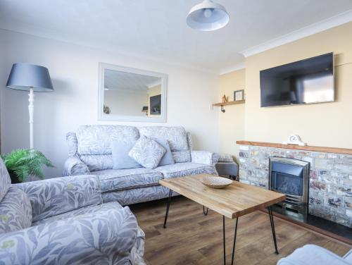a living room with a couch and a fireplace at Glasfryn in Holyhead