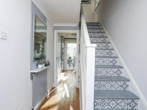 a hallway with a staircase with blue and white tiles at Glasfryn in Holyhead